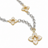 A silver and gold chain necklace featuring mother-of-pearl flower charms, photographed on a clean white background.