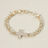14K gold plated abstract chain bracelet with CZ stone paved cross accent and adjustable clasp closure on a beige background