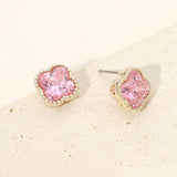 14K gold plated pink cubic zirconia quatrefoil stud earrings on beige stone background.
