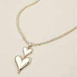 14K gold plated double heart drop pendant necklace on beige background