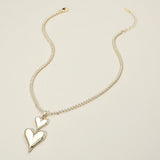14K gold plated double heart drop pendant necklace on beige background