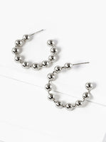Silver beaded hoop earrings on a white background
