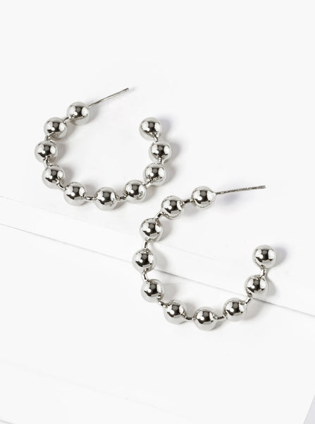 Silver beaded hoop earrings on a white background