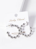 Silver beaded earrings on a 'Lucky Charm' branded card with a white background