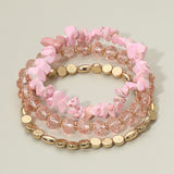 Three-piece blush pink stretch bracelet set featuring natural stone chips, faceted crystal beads, and polished gold accent beads on a light background