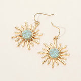 Gold celestial sunburst drop dangle earrings with textured boho-inspired statement design and fish hook backs.