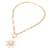 Gold celestial sunburst pendant necklace with white opal-inspired center and modern link chain on white background