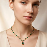 Woman wearing emerald green crystal bezel station necklace with square stone pendant gold tone lifestyle