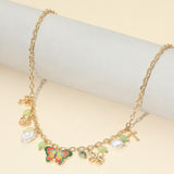 Gold necklace with colorful charms on a light gray surface