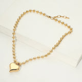 Gold bracelet with a heart-shaped charm on a white background