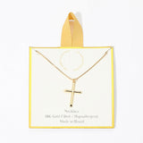 Gold necklace with cross pendant on a clear card with yellow border
