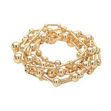 Seven-piece gold stretch bracelet set featuring polished geometric ball and bar bead designs for a modern layered look on a white background
