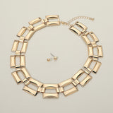 Polished gold open rectangle link statement necklace and ball stud earring set on cream background