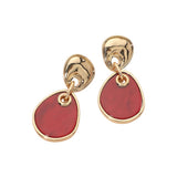 Gold earrings with red stones on a white background