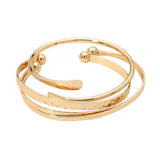Three-piece gold dipped minimalist bracelet set featuring layered bangles and open cuff designs for elegant everyday styling on a white background