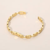 Gold stainless steel modern link hinged bangle bracelet featuring polished elongated chain links and a secure hinged closure on a beige background