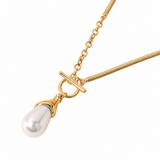 A gold chain necklace featuring a teardrop-shaped white pearl pendant held in a gold setting, suspended from a toggle clasp on a gold snake chain, shown against a plain white background.