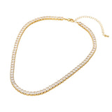 Gold necklace with clear stones on a white background
