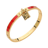 Red enamel hinged bangle bracelet with gold-tone stainless steel finish and lock charm accent on a white background.