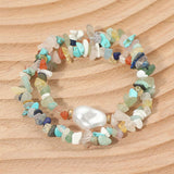 wo-piece stretch bracelet set featuring semi-precious pebble stones in soft pastel hues with an organic pearl accent on a wooden surface