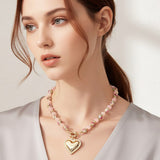 Woman wearing a necklace with a heart pendant on a plain background