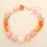 Chunky marbled blush pink orange resin pebble bead statement necklace detail on cream background