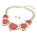 Gold heart statement necklace with red heart inlays and matching gold stud earrings on a white background.