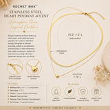 A gold layered necklace set presented on a beige background with printed product information. The set includes a herringbone chain and a heart pendant accent, shown in a large loop with inset detail views of the lobster clasp and heart pendant.