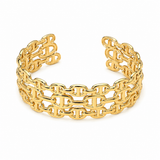 A gold-tone metal cuff bracelet featuring a repeating interlocking double-T link pattern, shown on a plain white background.