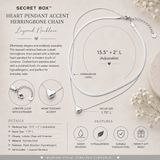 Silver layered herringbone chain necklace with a heart pendant, presented on a beige background with product details, specifications, and care icons.