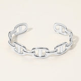 Silver chain bracelet on a light beige background. SECRET BOX stainless steel mariner link cuff bracelet in white gold tone. 