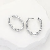 Silver CZ hardware link huggie hoop earrings with sparkling pave accents and modern chain-inspired design.