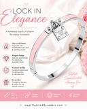 Silver stainless steel hinged bangle bracelet featuring pink enamel inlays and a decorative lock charm with polished finish on a white background.