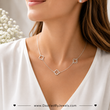 Sterling silver dipped open quatrefoil link station necklace with three elegant clover charms on an adjustable chain displayed on a white background styled look on model