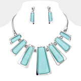 A silver-tone statement necklace and matching drop earrings with light aqua rectangular stone inlays, displayed on a white mannequin bust.