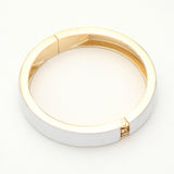 White enamel hinged bangle bracelet with gold tone finish and sleek minimalist design on a white background