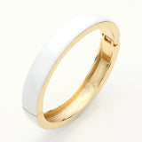 White enamel hinged bangle bracelet with gold tone finish and sleek minimalist design on a light grey background