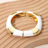 White enamel inlay square hinged bangle bracelet with polished gold tone geometric accents.