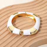 White enamel inlay square hinged bangle bracelet with polished gold tone geometric accents.
